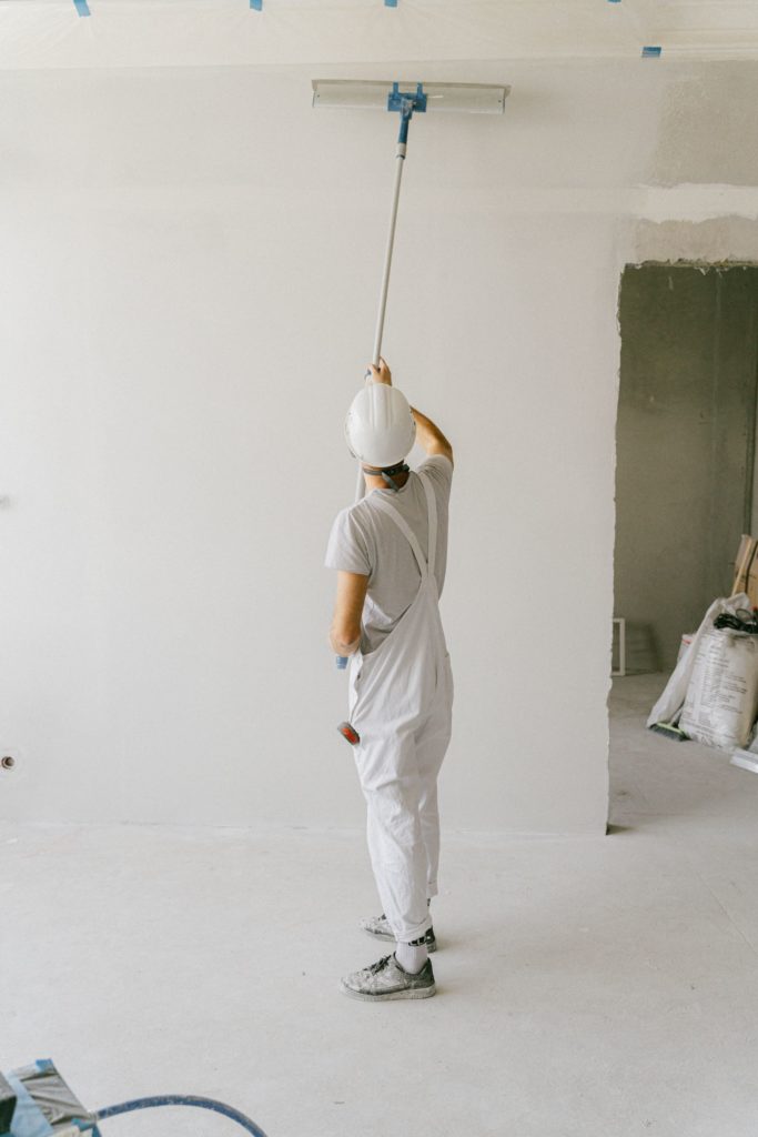 Painter rolling a ceiling with an extension pole