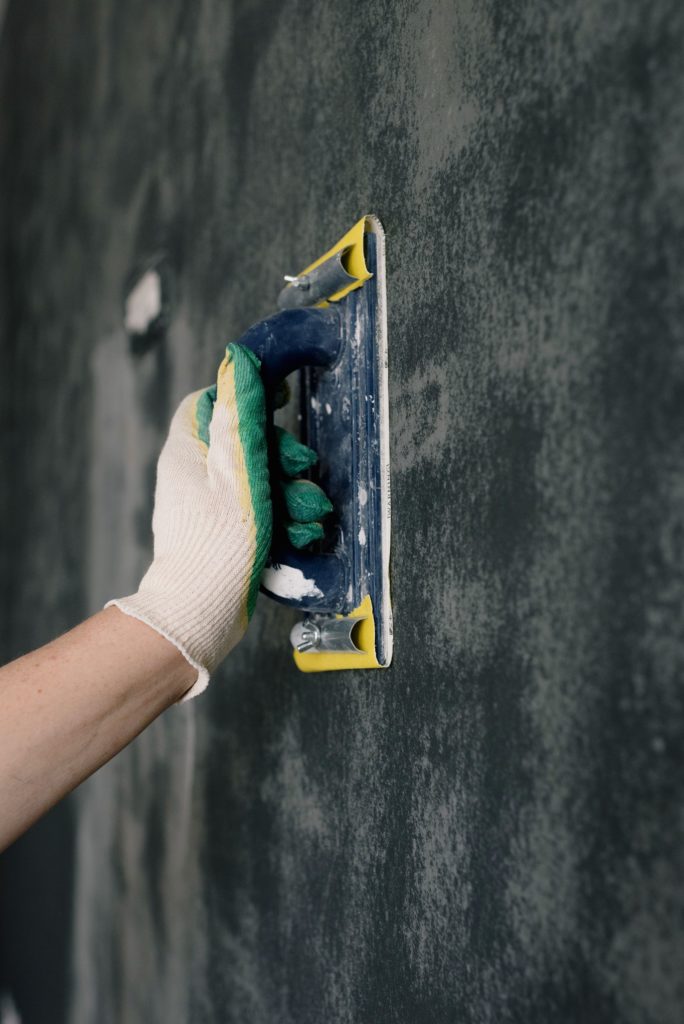 Hand sanding a wall with a sanding block