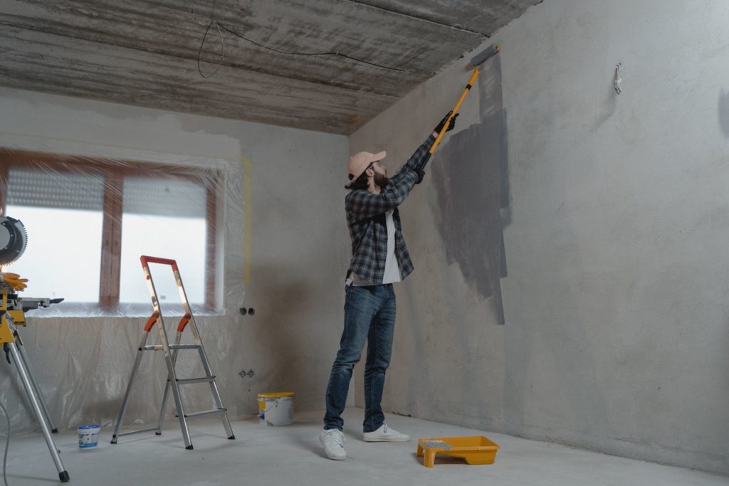 Painter rolling paint onto a wall