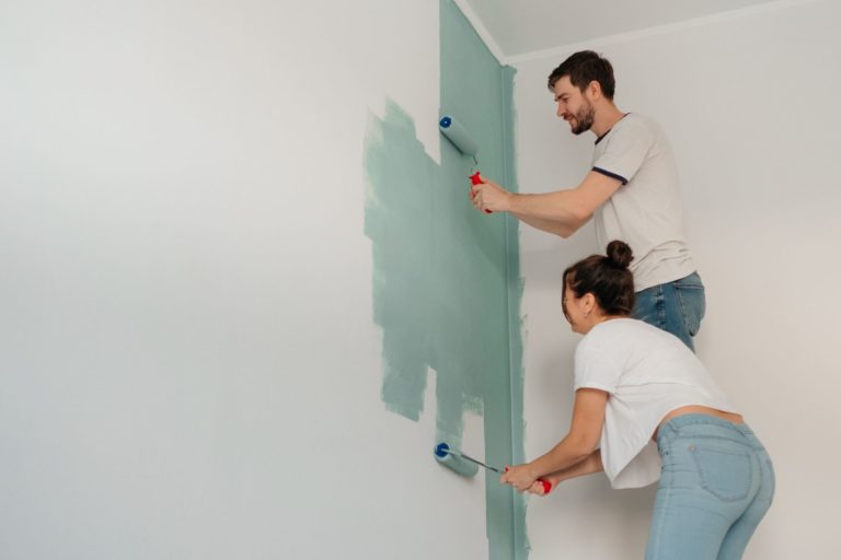 Couple painting a wall sage green