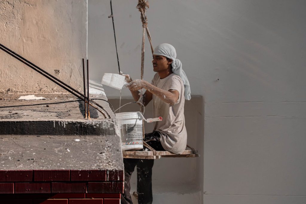 Painter working on a building wall